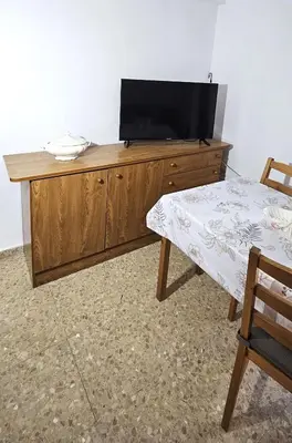 a wooden entertainment center with a flat screen tv on it at Vacansis Apartamento Cullera Mar in Cullera