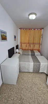 two beds in a small room with a window at Vacansis Apartamento Cullera Mar in Cullera