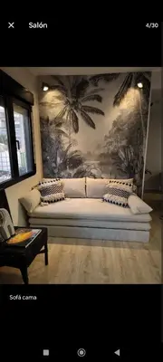 a bedroom with a bed with a mural of palm trees at Casa con piscina junto al mar in El Perellonet