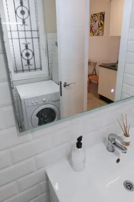 a bathroom with a washing machine in a mirror at Colomer Silence in Valencia