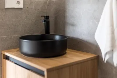a black sink sitting on top of a wooden counter at Suite Premium junto al Río Turia 1 in Valencia