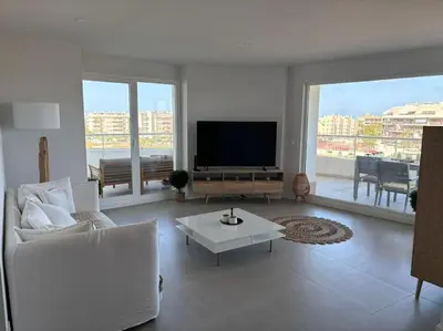 a living room with a television and a white couch at Appartement avec vue piscine in Canet de Berenguer