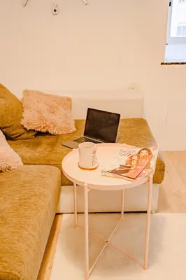 a coffee table with a laptop on a couch at Cabanal Beach House - 10 min to ocean , FastWifi , SmartTV, AC in Valencia