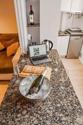 a bottle of wine on a counter with wine glasses at Cabanal Beach House - 10 min to ocean , FastWifi , SmartTV, AC in Valencia