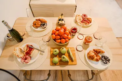 a wooden table with plates of food on it at Cabanal Beach House - 10 min to ocean , FastWifi , SmartTV, AC in Valencia