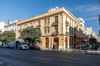 a large yellow building on a city street with cars at Premium Suite by the Turia River 3 in Valencia