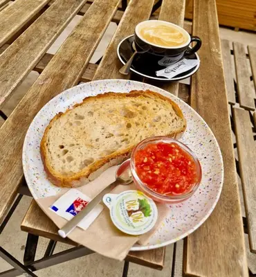 a sandwich on a plate with a cup of coffee and sauce at Premium Suite by the Turia River 4 in Valencia