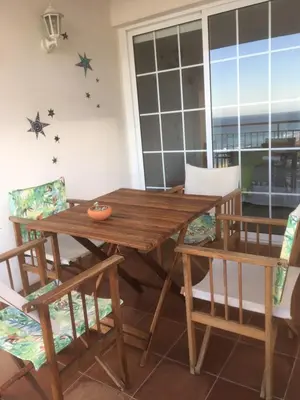 a wooden table and chairs in a room at La Calita del Versalles in Faro de Cullera