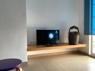 a tv sitting on a shelf in a room at La Calita del Versalles in Faro de Cullera