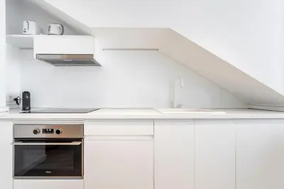 a white kitchen with a sink and a stove at BiS Suites Ruzafa in Valencia