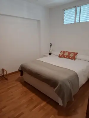 a bedroom with a large bed in a white room at Fleming's Beach in Puebla de Farnals