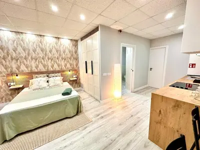 a large room with a bed and a kitchen at Estudio Benicalap in Valencia
