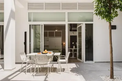 a white dining room with a table and chairs at Gran Turia Apartments in Valencia