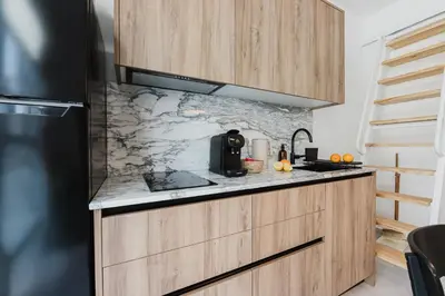 a kitchen with wooden cabinets and a black refrigerator at Gran Turia Apartments in Valencia