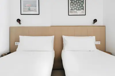 two beds in a hotel room with white pillows at White Beach Apartment in Valencia
