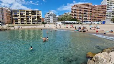 a group of people in the water at a beach at Relax & Sea View & Beach Access in Faro de Cullera