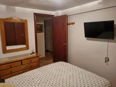 a bedroom with a bed and a television on the wall at Casa Amando in Chulilla