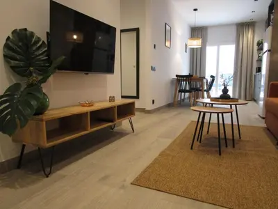 a living room with a tv and a table and chairs at Travel Habitat Ruzafa Green House Terrace in Valencia