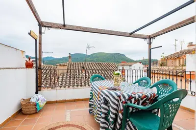 a table and chairs on a balcony with a view at La Casita De La Dormilona in Algimia de Almonacid