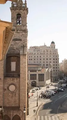 a tall brick building with a clock tower on a street at Piso 3 - Apartamento Mercado Central in Valencia