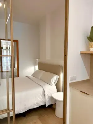 a bedroom with a white bed and a toilet at Anelsa Suites Serranos 1 in Valencia