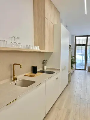 a kitchen with white cabinets and a sink at Anelsa Suites Serranos 1 in Valencia