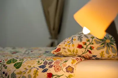 a lamp sitting on top of a bed with a pillow at Luminoso Apartamento Familiar y Patio Privado in Valencia