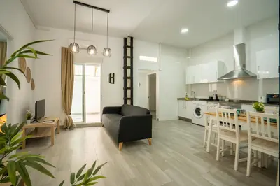 a living room and kitchen with a couch and a table at Luminoso Apartamento Familiar y Patio Privado in Valencia