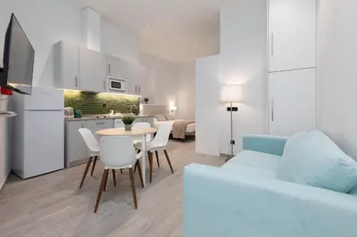 a living room with a couch and a table and chairs at Apartamento 3º nuevo a estrenar cerca del mar in Valencia