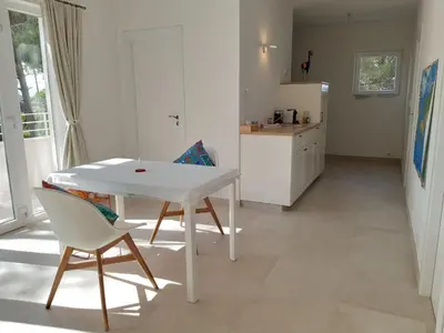 a kitchen with a white table and two chairs and a refrigerator at Casa Kiosko 3 bedroom chalet with swimming pool in La Eliana