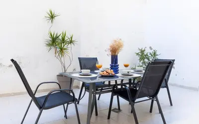 a dining room table with two chairs and a blue vase at Casa Montserrat in Valencia
