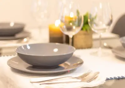 a white bowl on a plate on a table with wine glasses at Casa Montserrat in Valencia