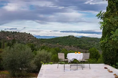 a table with two chairs and oranges on it at El mirador de la Sonora in Artana