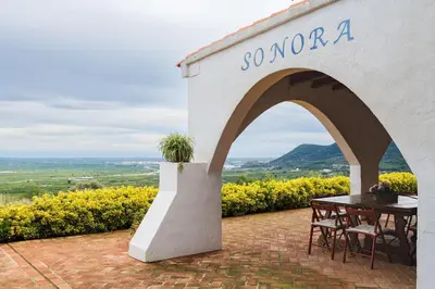 a patio with a table and a sign that reads so mora at El mirador de la Sonora in Artana