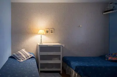 a room with two beds and a table with a lamp at El mirador de la Sonora in Artana