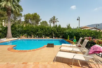 a swimming pool with two lounge chairs next to it at Luxury villa close to beach, mountain and golf! in Alzira