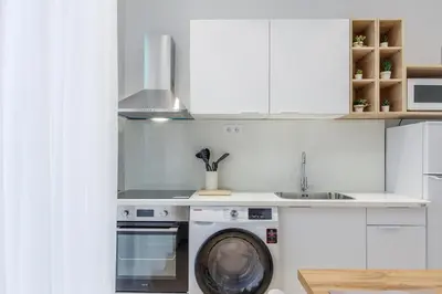 a kitchen with a washing machine and a sink at Apartamentos Grupo Torres de Quart in Valencia