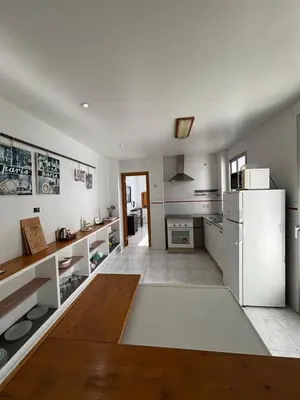 a kitchen with white appliances and a wooden table at Casa Lúmina Laura-Valencia in Valencia