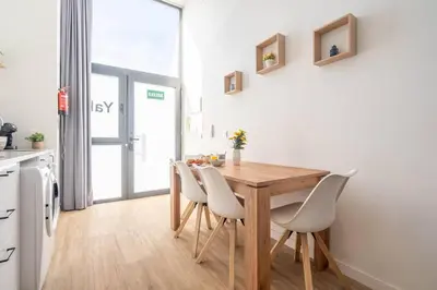 a kitchen with a wooden table and white chairs at Vlc Yako Suite in Valencia