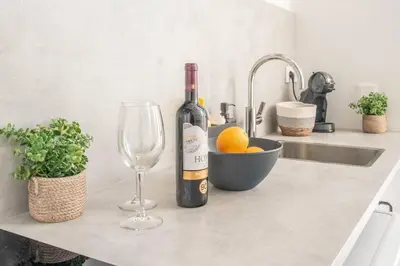 a bottle of wine and a glass on a kitchen counter at Vlc Yako Suite in Valencia