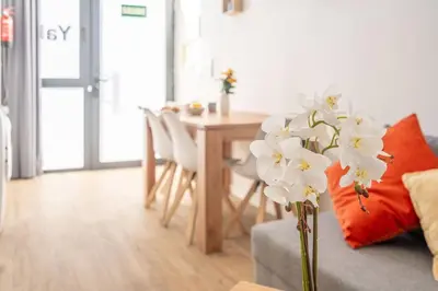 a living room with a table and a vase of flowers at Vlc Yako Suite in Valencia