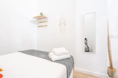 a white room with a bed and a mirror at Vlc Yako Suite in Valencia