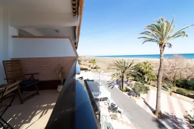 a white bedroom with two beds and a window at Global Vacacional, Apartamento en primera linea con impresionantes vistas al mar in Canet de Berenguer