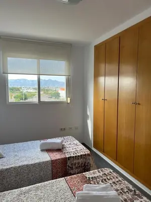 a bedroom with two beds and a cabinet and a window at Moncofa Sunset in Moncófar