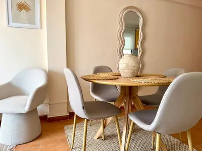 a dining room with a table and chairs and a mirror at Casa Palmera in Sueca