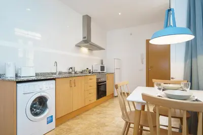 a kitchen with a table and a washing machine at Apartamentos Mercat in Valencia