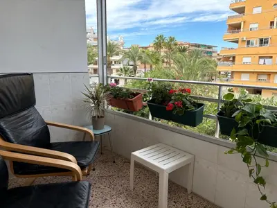 a balcony with a chair and potted plants on it at Parking Privado l Terraza Relajante Junto Al Mar in Tavernes de Valldigna