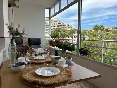 a dining room table with a view of a city at Parking Privado l Terraza Relajante Junto Al Mar in Tavernes de Valldigna