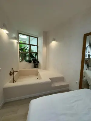 a white bath tub in a room with a bed at Anelsa Suites Serranos 3 in Valencia