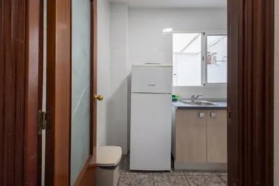 a small kitchen with a refrigerator and a sink at Cómodo apartamento cerca del metro y de la feria Valencia in Paterna